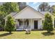 Inviting home exterior showcasing a cozy front porch, manicured lawn, and well-placed greenery at 722 E Pine Ave, Wake Forest, NC 27587