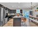 Modern kitchen featuring dark cabinetry, stainless steel appliances, a granite island, and an adjacent dining area at 743 Hadstock Path Path, Zebulon, NC 27597