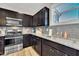 Modern kitchen features stainless steel appliances, dark cabinets, gray backsplash, and granite countertops at 743 Hadstock Path Path, Zebulon, NC 27597