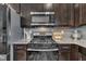 Close up on a gas cooktop, stainless appliances, with gray backsplash and granite countertops at 743 Hadstock Path Path, Zebulon, NC 27597