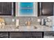 Close-up of kitchen sink featuring granite countertops, gray backsplash, and modern faucet at 743 Hadstock Path Path, Zebulon, NC 27597