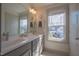 Bathroom view of vanity with double sinks and large mirror, with a window viewing outside at 777 Fireball Ct, Knightdale, NC 27545