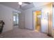 Bright, carpeted bedroom featuring neutral walls, ceiling fan, and doorways to the bathroom and hallway at 777 Fireball Ct, Knightdale, NC 27545
