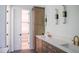 Modern bathroom featuring dual sinks, quartz countertops, and stylish light fixtures, and closet at 7805 Ailesbury Rd, Wake Forest, NC 27587