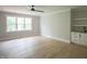 Inviting bedroom featuring hardwood floors, a ceiling fan, a wet bar, and a window with natural light at 7805 Ailesbury Rd, Wake Forest, NC 27587