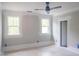 Unfinished bedroom showing freshly painted white trim, two windows, and a ceiling fan prep at 7805 Ailesbury Rd, Wake Forest, NC 27587