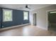 Comfortable bedroom with hardwood floors, ceiling fan, two windows, and ensuite bathroom for convenience at 7805 Ailesbury Rd, Wake Forest, NC 27587