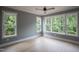 Well-lit bedroom with hardwood floors, large windows offering a view of the lush, green surroundings at 7805 Ailesbury Rd, Wake Forest, NC 27587