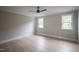 Spacious bedroom featuring hardwood floors and natural light from two windows at 7805 Ailesbury Rd, Wake Forest, NC 27587
