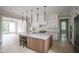 Open-concept kitchen with a large island, stainless appliances, and white cabinets with gold hardware at 7805 Ailesbury Rd, Wake Forest, NC 27587