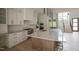 Gorgeous kitchen with island, stainless appliances, white cabinetry, and stairs leading to the upper level at 7805 Ailesbury Rd, Wake Forest, NC 27587