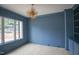 Blue office space featuring hardwood floors, built-in bookshelves, large window, and unique light fixture at 7805 Ailesbury Rd, Wake Forest, NC 27587