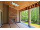 Inviting covered patio with a brick fireplace and a beautiful view of the surrounding nature at 7805 Ailesbury Rd, Wake Forest, NC 27587