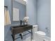 Stylish powder room with a modern vessel sink, gold mirror, and sleek toilet in cool blue tones at 805 Tower St # 102, Raleigh, NC 27607