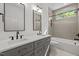 Bright bathroom featuring double vanity with gray cabinets, modern fixtures, and a shower-tub combo at 805 Tower St # 102, Raleigh, NC 27607