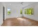 Open bedroom with hardwood floors, multiple windows, and a ceiling fan at 805 Tower St # 102, Raleigh, NC 27607