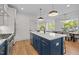 Elegant kitchen featuring stainless appliances, a quartz countertop island, and views into the dining area at 805 Tower St # 102, Raleigh, NC 27607