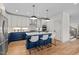 Modern kitchen with white cabinets, blue island, quartz countertops, stainless steel appliances, and breakfast bar at 805 Tower St # 102, Raleigh, NC 27607