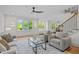 Open living room with hardwood floors, large windows, and views to a dining area and staircase at 805 Tower St # 102, Raleigh, NC 27607