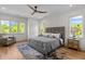 Bright main bedroom with large bed, windows overlooking trees, ceiling fan and hardwood floors at 805 Tower St # 102, Raleigh, NC 27607