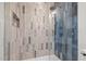 Luxurious shower with gray and white patterned tile walls and a glass door at 805 Tower St # 102, Raleigh, NC 27607