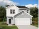 Charming two-story home with light gray siding, a white garage door, and a well-manicured front lawn at 813 Kenyon Spring Dr, Zebulon, NC 27597