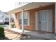 Inviting brick front porch with white columns, shutters, and space for seating with an attractive front door at 8511 Bright Loop, Raleigh, NC 27613