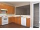 Bright kitchen with wood cabinets, white appliances, a pantry, and an opening looking into the living area at 8511 Bright Loop, Raleigh, NC 27613