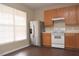 Well-lit kitchen with stainless steel refrigerator, modern appliances, wood cabinets, and wood flooring at 8511 Bright Loop, Raleigh, NC 27613