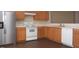 Kitchen view featuring stainless steel refrigerator, modern appliances, wood cabinets, and modern flooring at 8511 Bright Loop, Raleigh, NC 27613