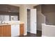 Kitchen view with wood cabinets, white appliances, a pantry, and an opening looking into the living area at 8511 Bright Loop, Raleigh, NC 27613