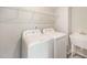Functional laundry room with modern washer, dryer, utility sink, and shelving for efficient organization at 1000 Sora Way, Durham, NC 27703
