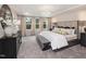 Luxurious main bedroom featuring tray ceiling, a comfortable bed, a decorative chandelier, and ample natural light at 1000 Sora Way, Durham, NC 27703