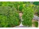 Aerial view showcases the brick home nestled among mature trees and lush greenery in a serene setting at 101 Easton Ct, Garner, NC 27529