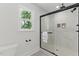 Modern bathroom features a glass shower with marble tile surround, a view to the backyard, and neutral paint at 101 Easton Ct, Garner, NC 27529