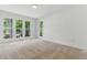 Bedroom featuring neutral carpet, white walls, and multiple windows offering views of the surrounding area at 101 Easton Ct, Garner, NC 27529