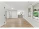 Spacious room with wood-look floors, neutral paint, a kitchenette, and a door to the outside at 101 Easton Ct, Garner, NC 27529