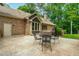 This large concrete patio has a metal table and chairs next to the brick home with a side entrance and well-kept lawn at 101 Easton Ct, Garner, NC 27529