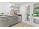 Stylish wet bar features granite countertop, mini fridge, shelves, and plank accent wall at 101 Easton Ct, Garner, NC 27529