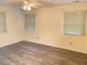 Sunlit bedroom with wood laminate flooring and two windows at 101 Woodbridge Ln, Chapel Hill, NC 27514