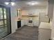 Well-lit kitchen with white cabinets, appliances, and laminate flooring at 101 Woodbridge Ln, Chapel Hill, NC 27514