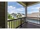 Wooden balcony with a view of neighborhood homes, green lawn, and blue sky at 1013 Oatney Ridge Ln, Morrisville, NC 27560