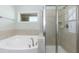 Bathroom featuring a soaking tub and walk-in shower with neutral tile and silver fixtures at 1013 Oatney Ridge Ln, Morrisville, NC 27560