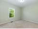 Bedroom with neutral walls and carpet with a window view to a green space at 1013 Oatney Ridge Ln, Morrisville, NC 27560