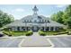 Community clubhouse featuring an elegant clock tower, manicured landscaping, and ample parking at 1013 Oatney Ridge Ln, Morrisville, NC 27560