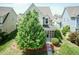 Aerial view of a charming two-story home with a well-maintained lawn and a lush green tree at 1013 Oatney Ridge Ln, Morrisville, NC 27560