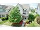 Aerial view of a charming two-story home with a well-maintained lawn and a lush green tree at 1013 Oatney Ridge Ln, Morrisville, NC 27560