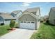 Exterior view features a two-car garage, manicured landscaping, and well-maintained lawn at 1013 Oatney Ridge Ln, Morrisville, NC 27560