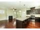 Open kitchen and living room with granite island, stainless steel appliances, and hardwood floors at 1013 Oatney Ridge Ln, Morrisville, NC 27560