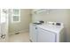 Bright laundry room with white front load washer and dryer, white shelves and window at 1013 Oatney Ridge Ln, Morrisville, NC 27560